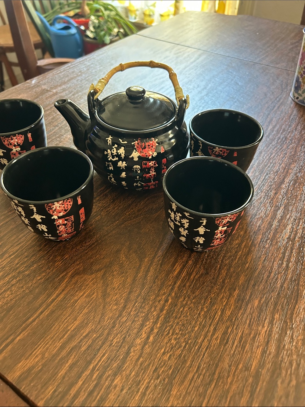 Chinese Calligraphy black glazed porcelain teapot with four cups.